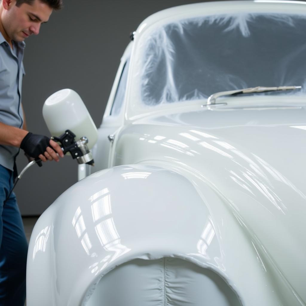 Applying thin coats of base and clear coat during car paint repair.