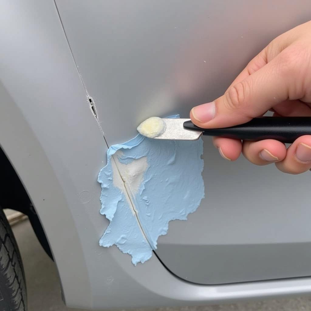 Applying Plastic Filler to a Damaged Car Bumper