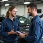 Mechanic explaining car repairs to a customer using a tablet