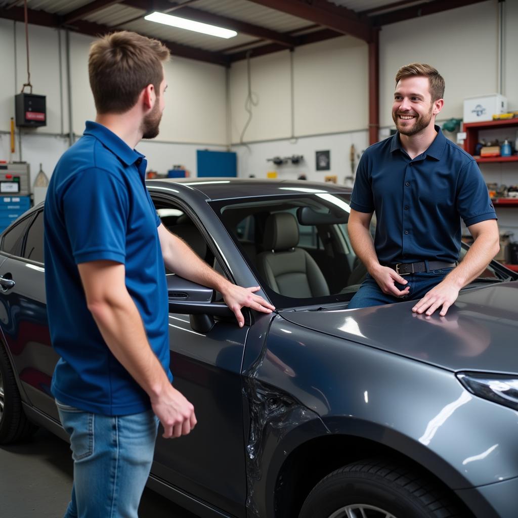 Customer consulting with a mechanic in an auto body shop