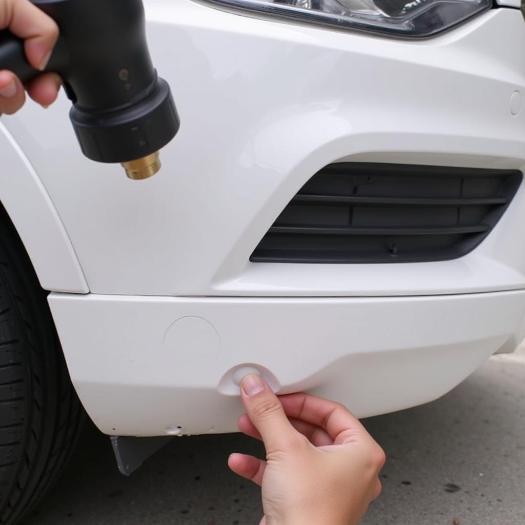 Repairing dents in a plastic car bumper with a heat gun