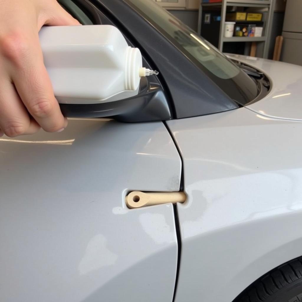 Applying hot glue method to repair small dent