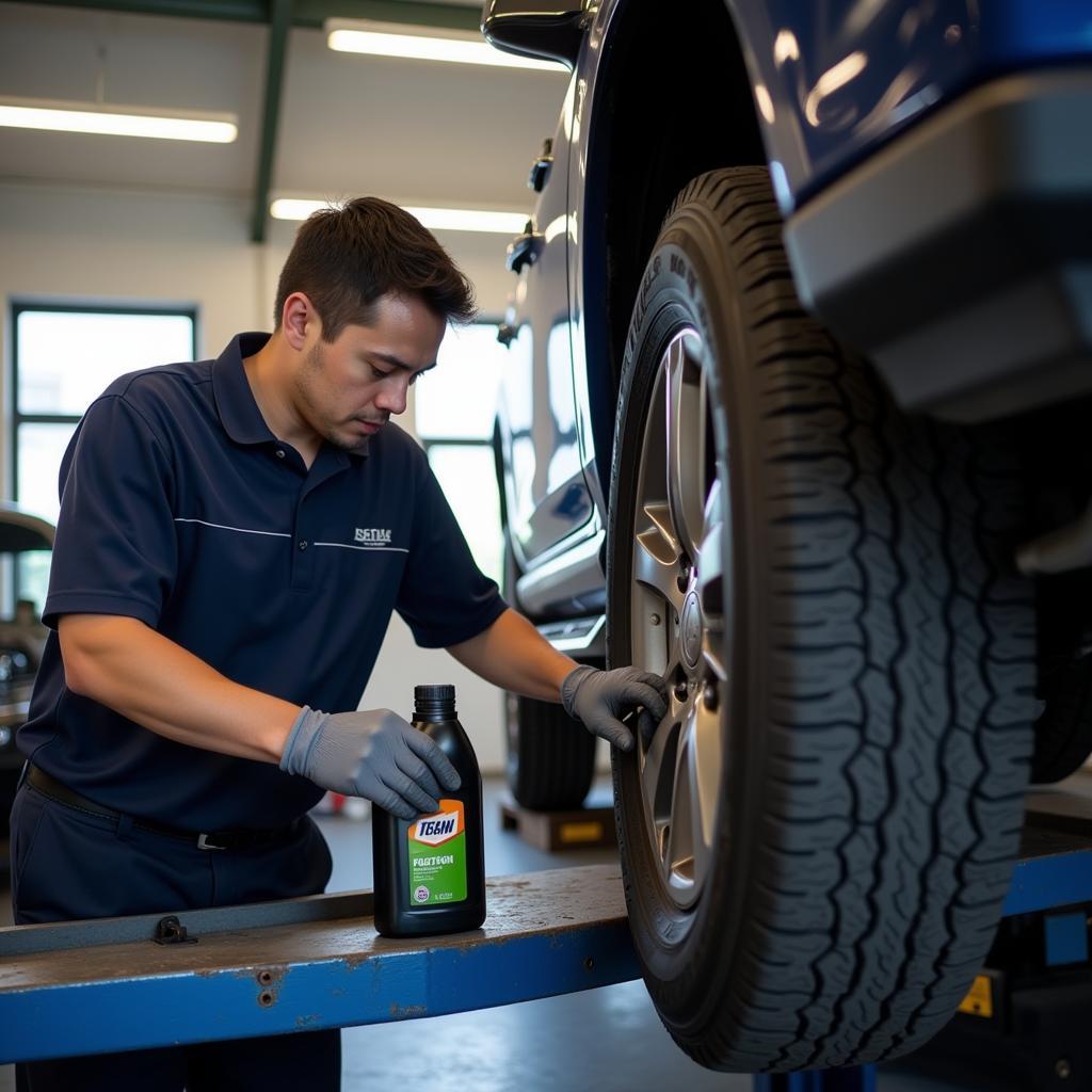 Auto service technician performing an oil change in Kula