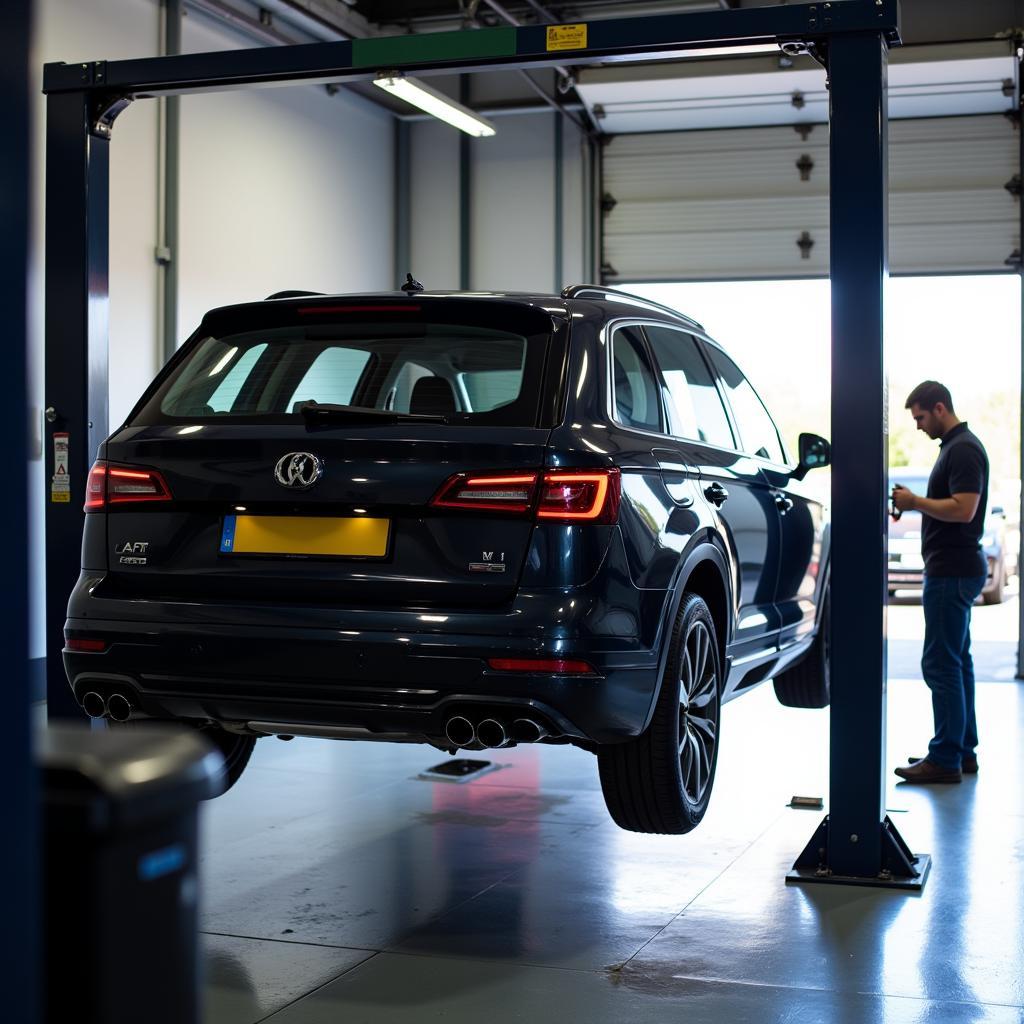 Car on a lift in a service bay for regular maintenance