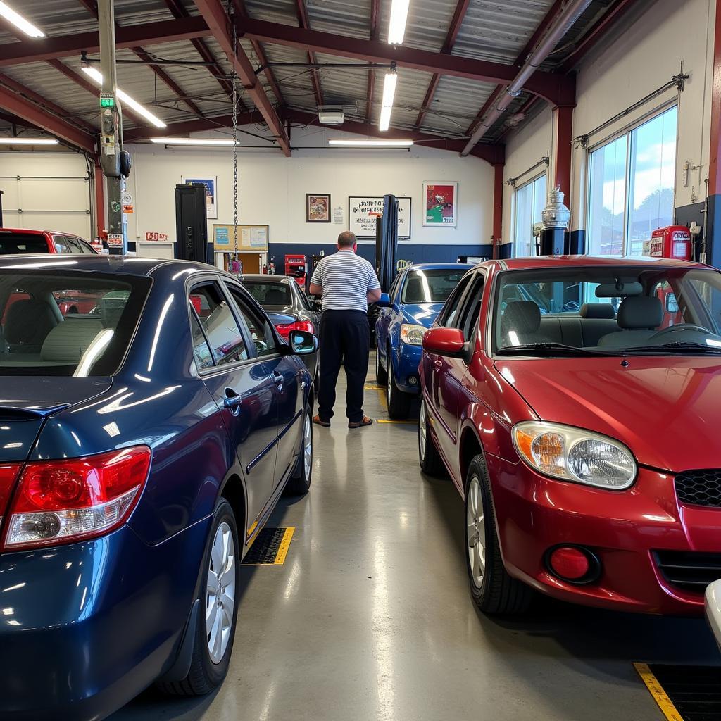 A busy auto repair shop in Ventura, CA with mechanics working on various cars.